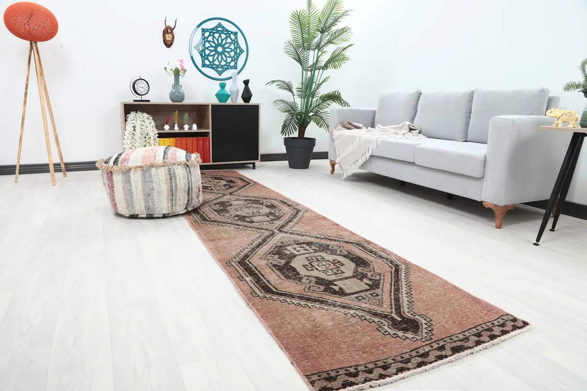Angled view of the rose and brown runner rug extending from the foreground into a living room
