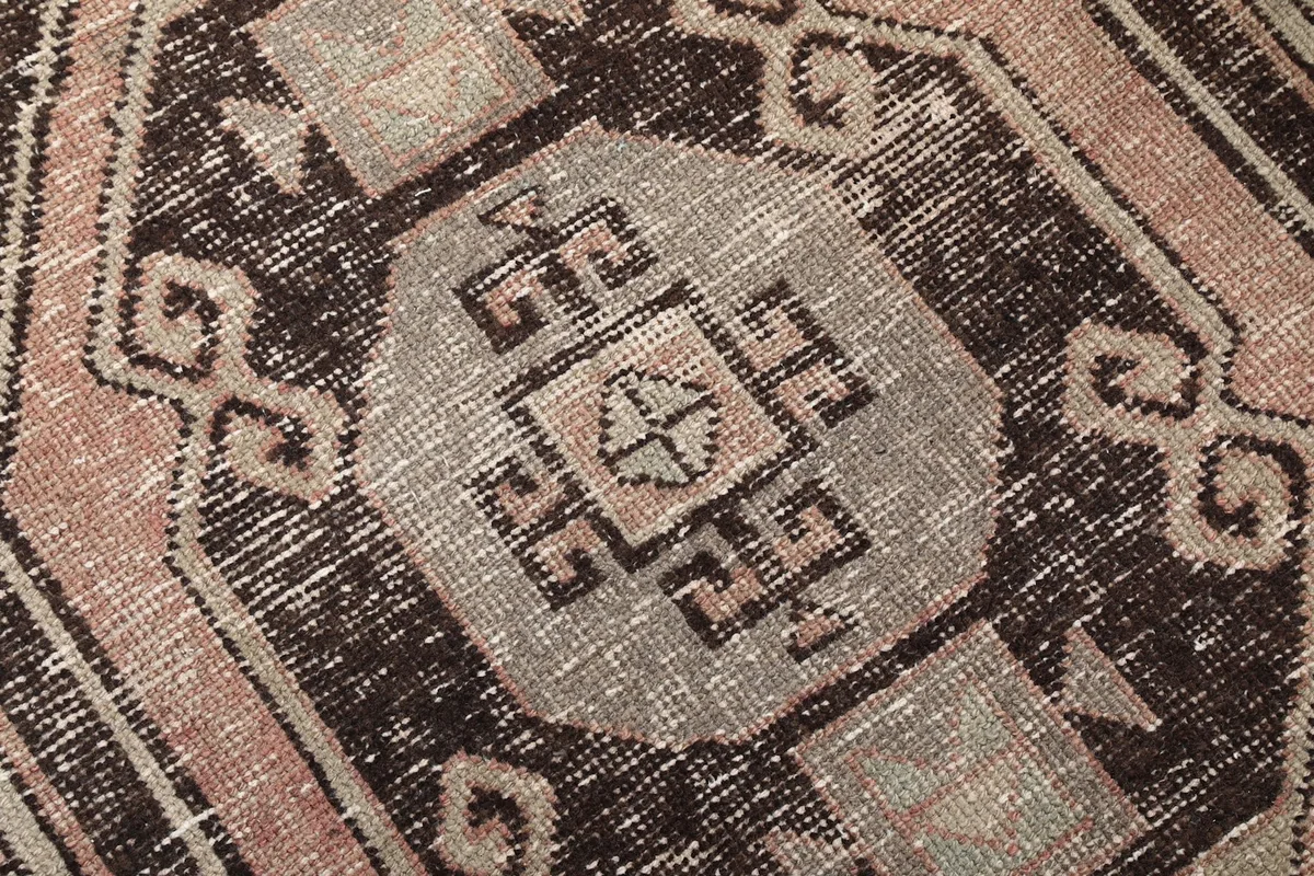 Extreme close-up showing the intricate geometric design and texture of the hand-knotted wool pile