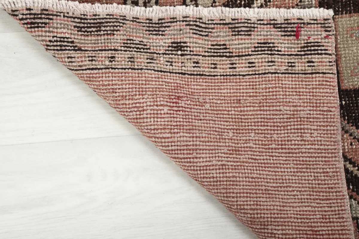 Close-up of the back of the hand-knotted wool rug, showing the tightly woven cotton foundation