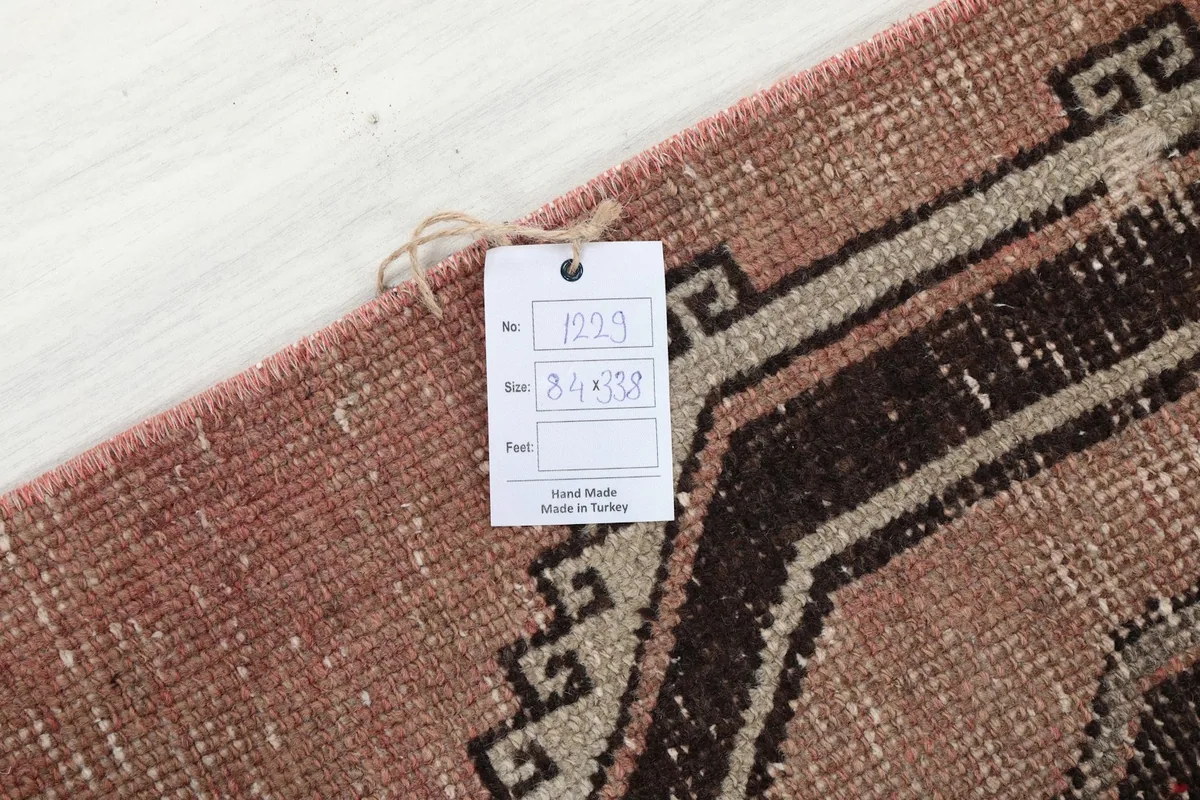 Detail of the rug with a product tag displaying its item number and dimensions (84 x 338 cm)