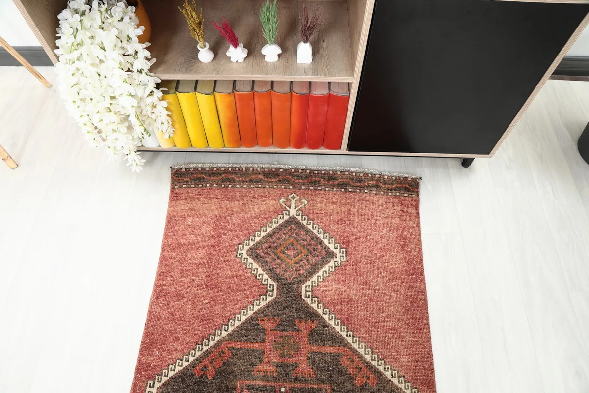 Top-down view of one end of the runner rug in a room, showing its placement near a cabinet.