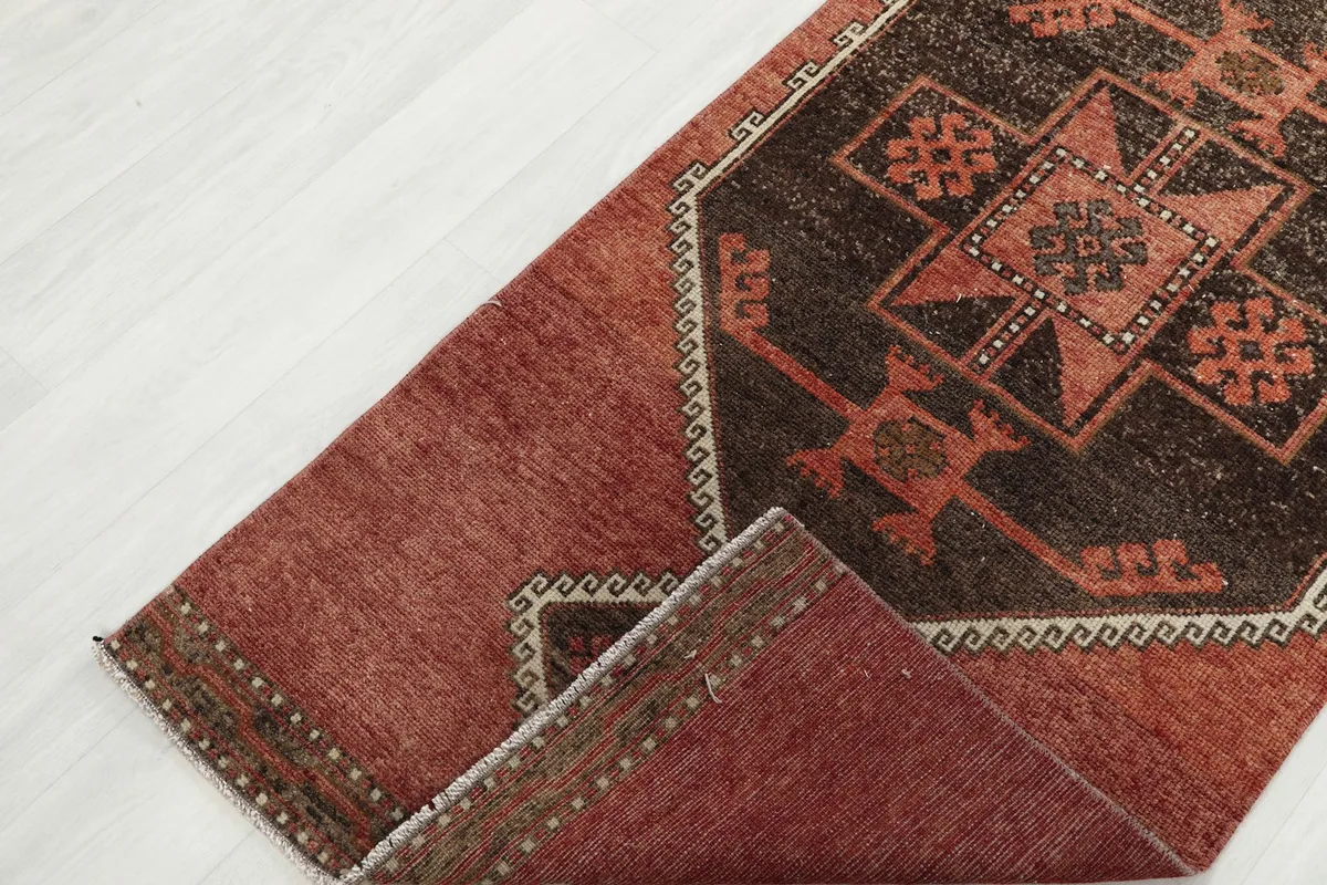 Angled view of the rug folded to show the thickness and flexibility of the vintage runner.