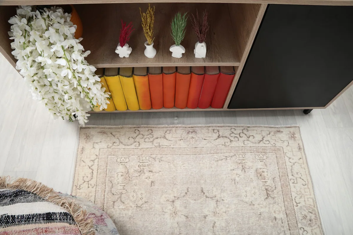 Overhead shot of the beige vintage rug, showing its placement in the room with furniture.
