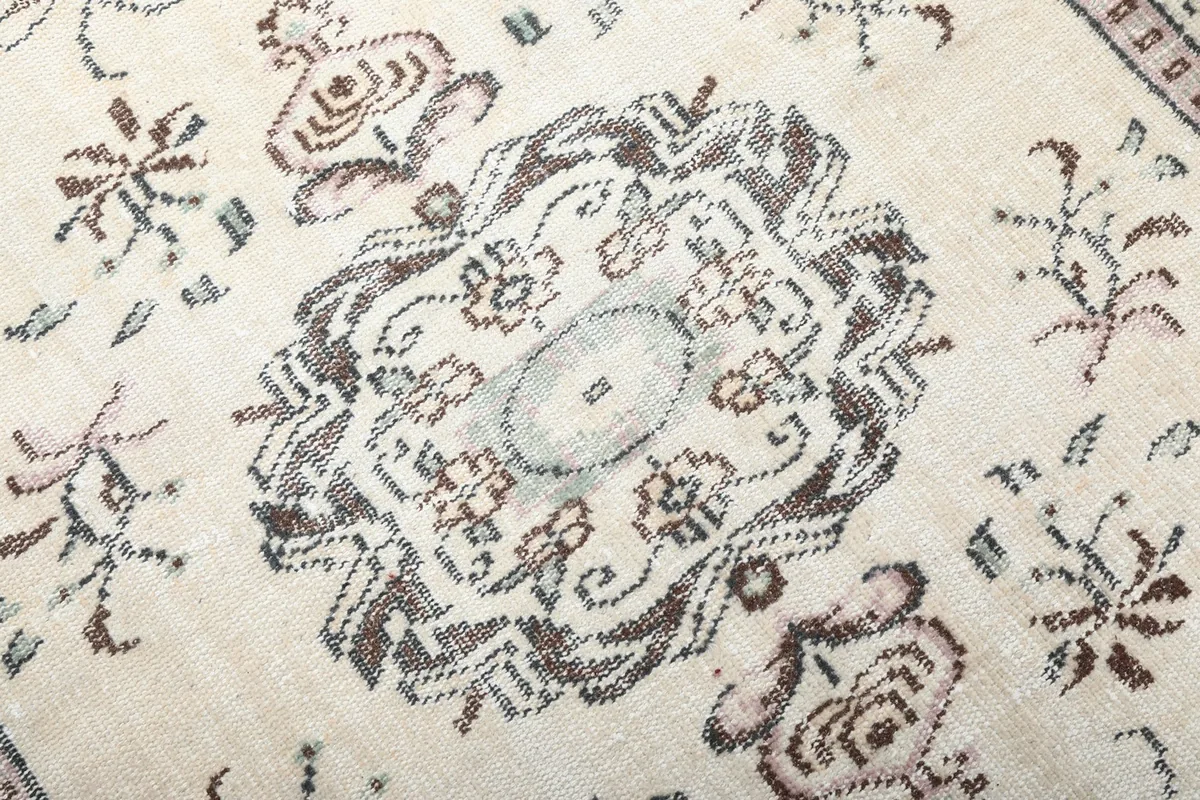 Detailed close-up of the central medallion design and surrounding faded patterns.