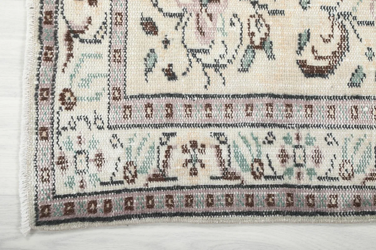 Close-up of the rug's intricate border design with geometric and floral elements.