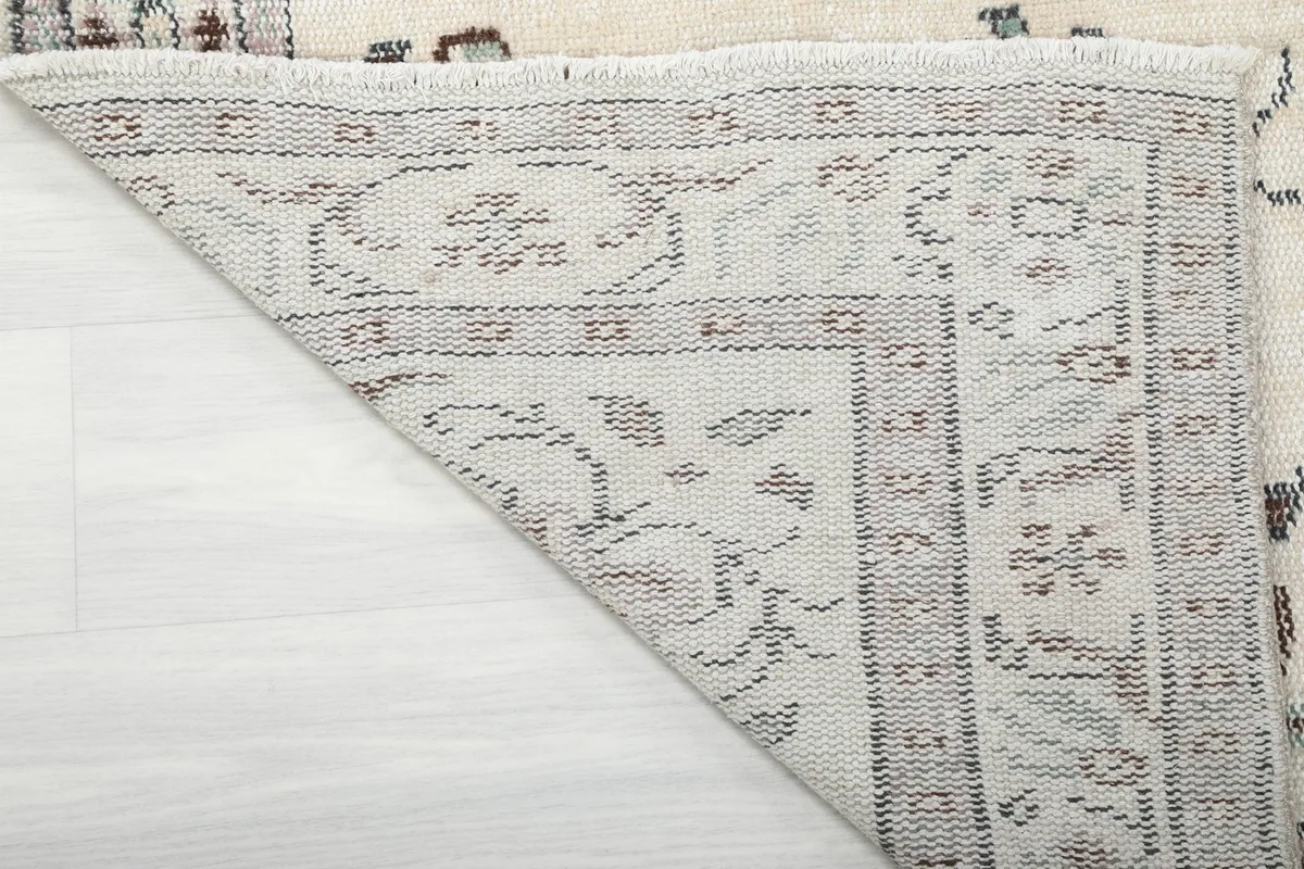 Close-up view of the back of the hand-knotted rug, revealing the cotton foundation.