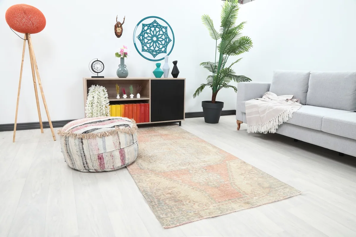 Angle view of the rose and beige vintage rug complementing a sofa and side table