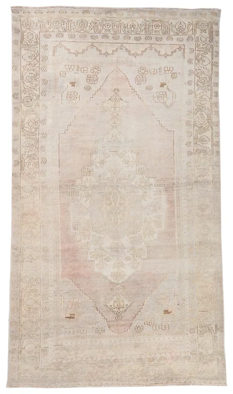 Full top view of the beige and rose vintage Anatolian area rug with a central medallion.