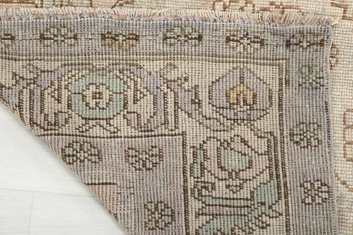 Close-up of the back of the rug, showing the woven cotton foundation and the tight hand-knotting.