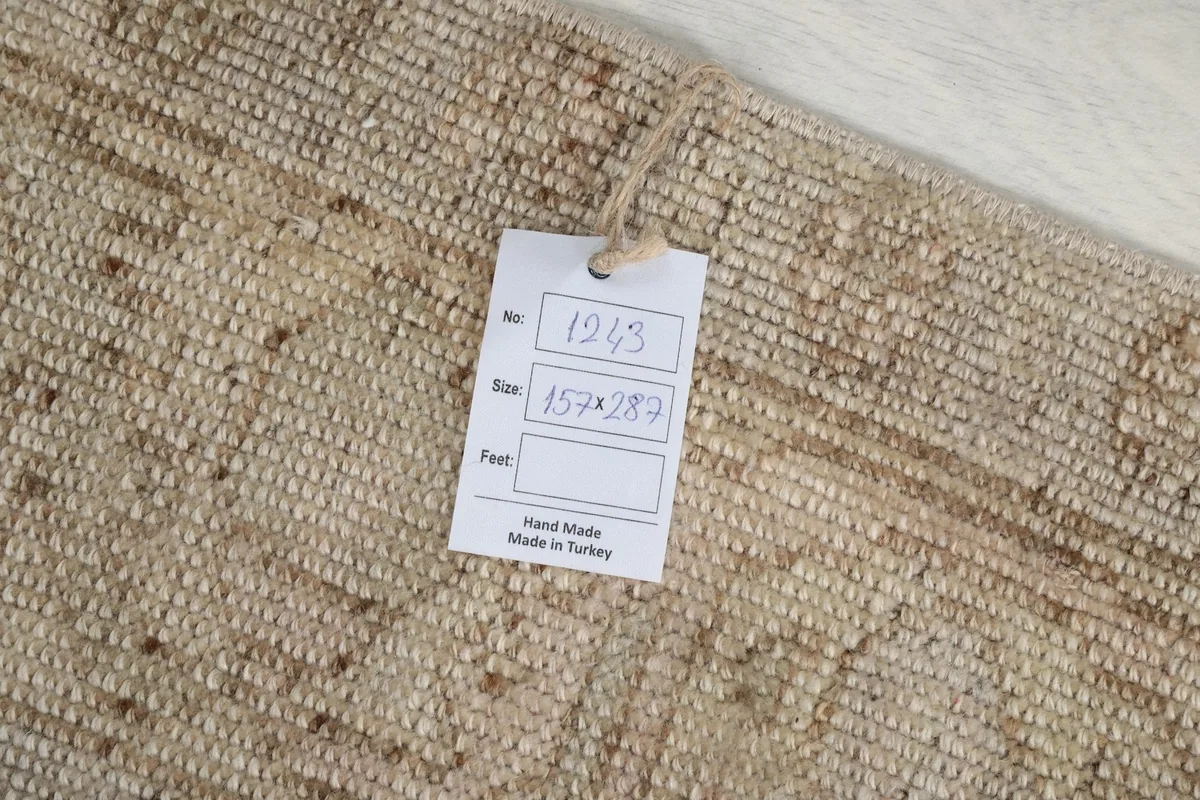 Label attached to the back of the rug, displaying its dimensions in centimeters and confirming hand-made origin.
