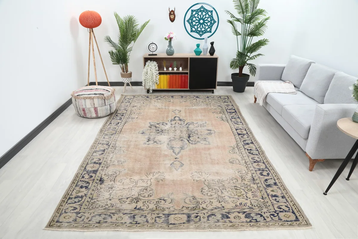 Vintage Anatolian area rug displayed in a living room setting with a gray sofa