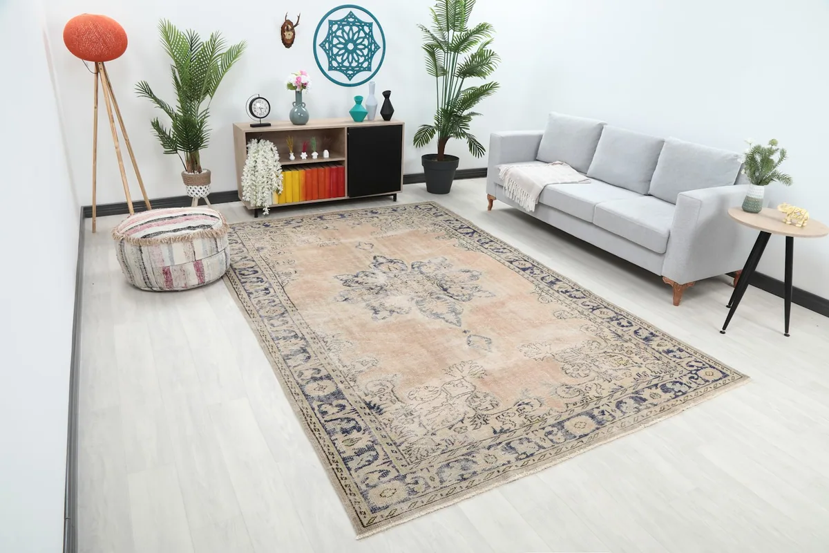 Large rose and navy vintage rug from an angle, showing its placement in a modern living space