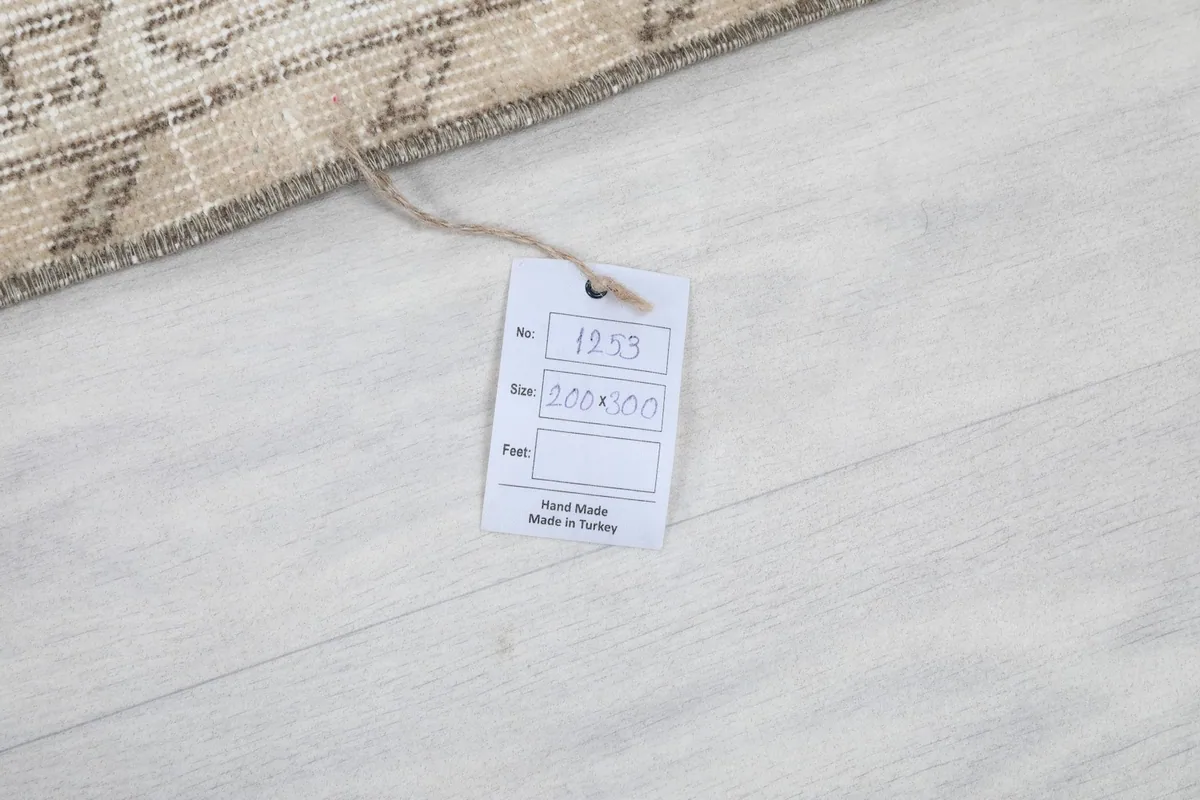 Product tag on the rug, indicating its size of 200x300 cm and handmade origin from Turkey.