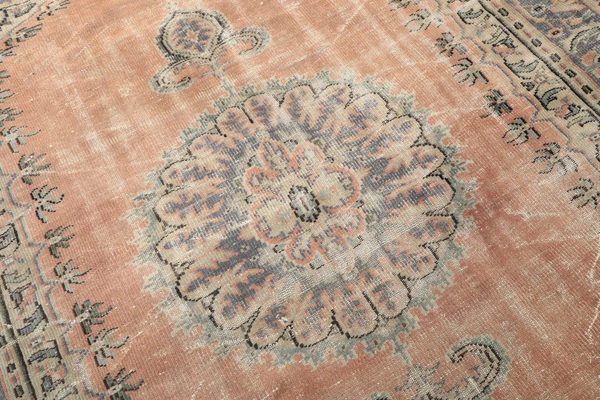 Close-up of the central medallion with its intricate gray, blue, and orange motifs