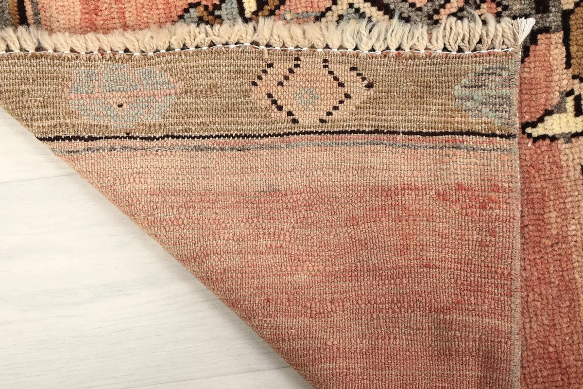 Underside of the rug showing the hand-knotted cotton foundation and the back of the wool pile.