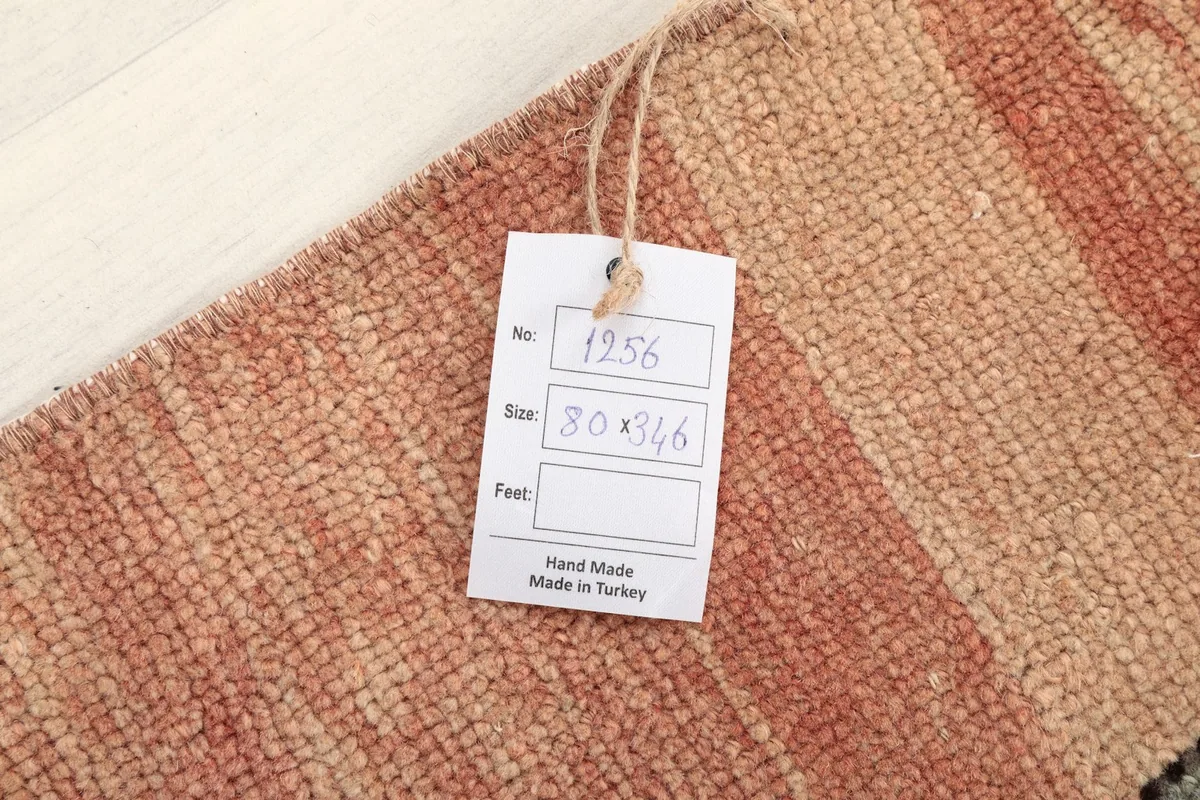 Close-up of the rug's surface with a tag indicating its unique number, size, and origin.