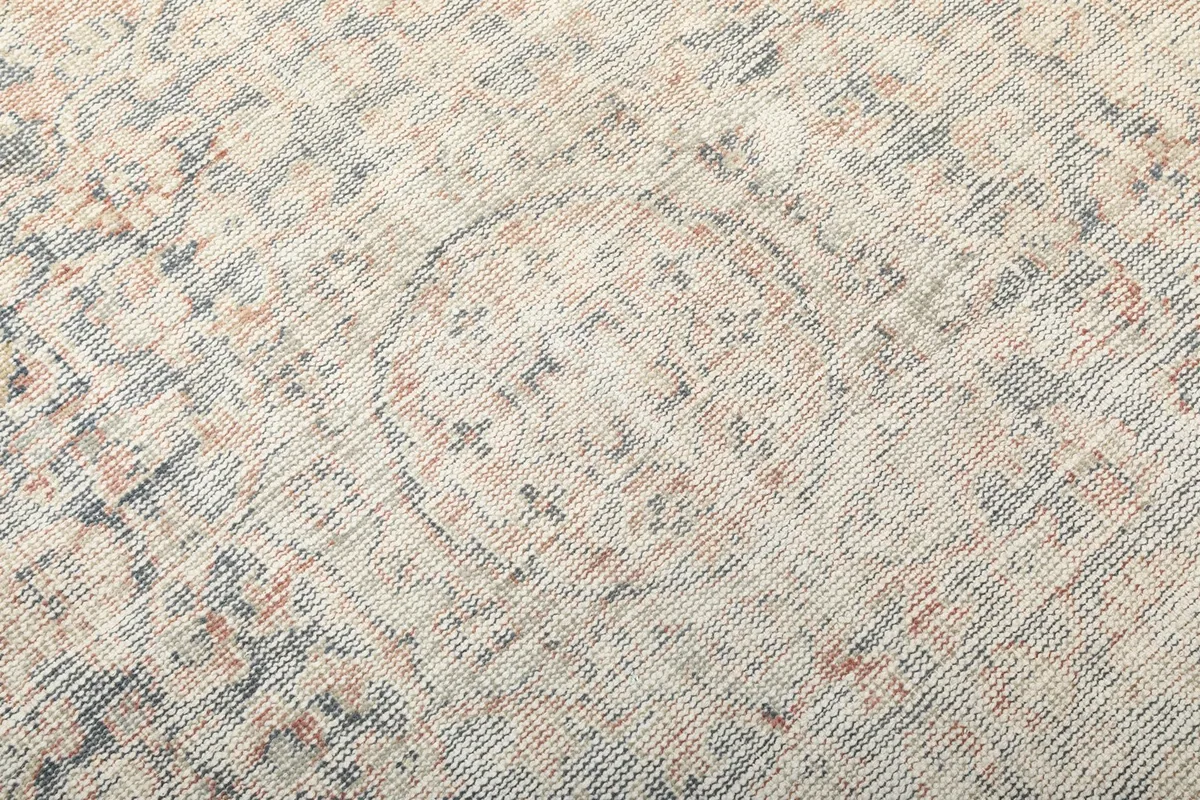 Close-up of the distressed wool pile and intricate, faded patterns on the rug