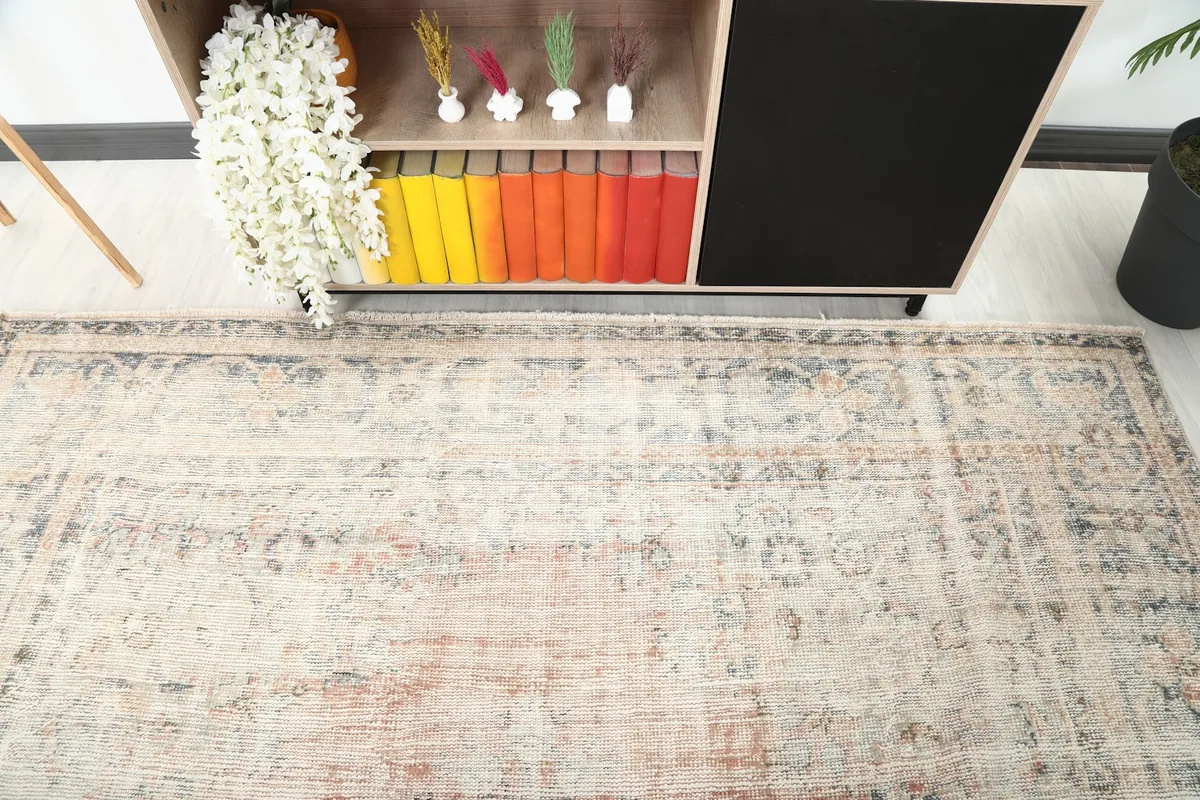 Top-down view focusing on the border and field of the vintage rug in a room