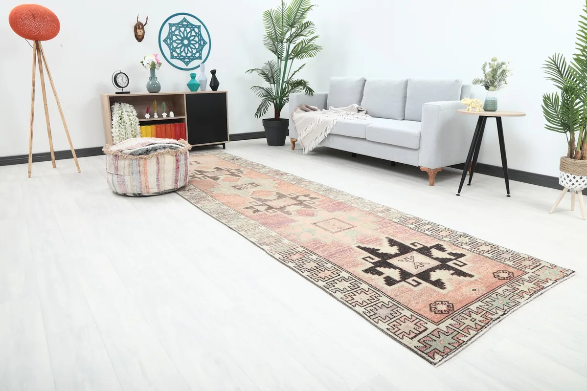 Angle view of the rust geometric runner rug in a contemporary room with a sofa and decor.