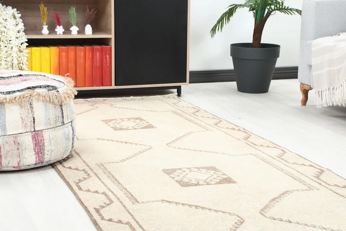 Close-up of the rug's geometric pattern near a decorative ottoman