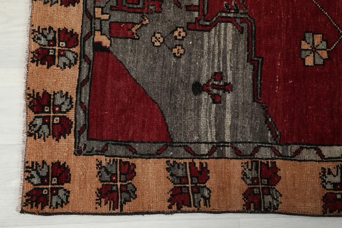 Detailed view of the tan and brown geometric border design of the vintage runner.