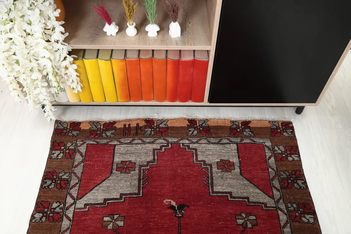 Overhead detail of one end of the red runner, showcasing the gray and tan geometric border.