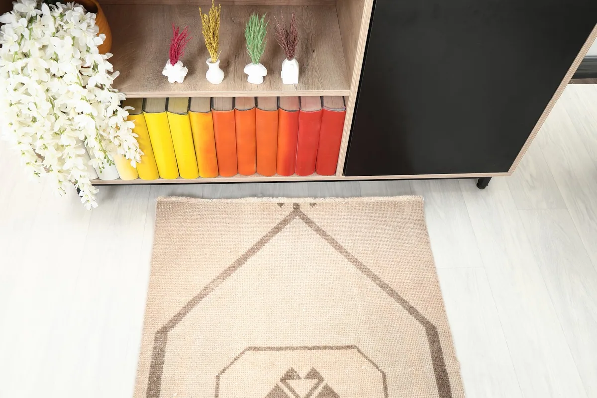 Top-down view of one end of the tan runner rug, highlighting the geometric design