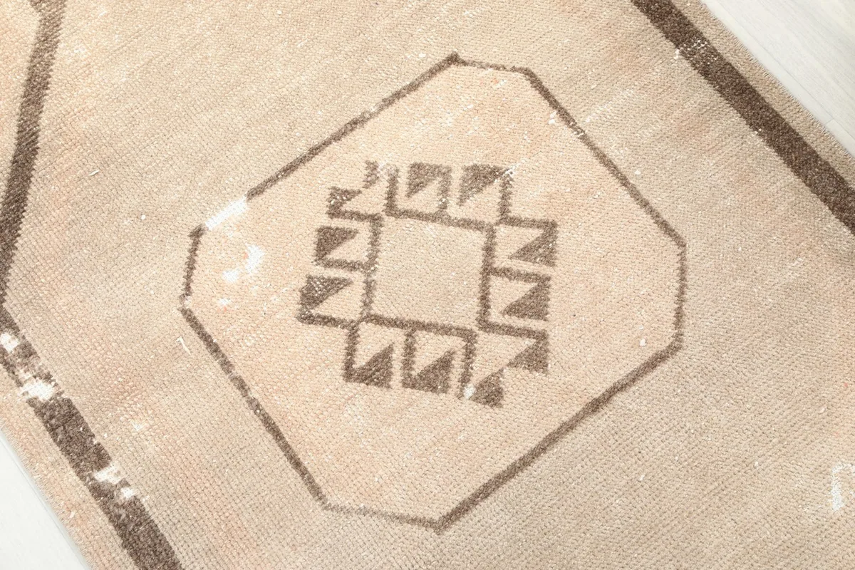 Close-up of a single tribal medallion motif and the tan background color