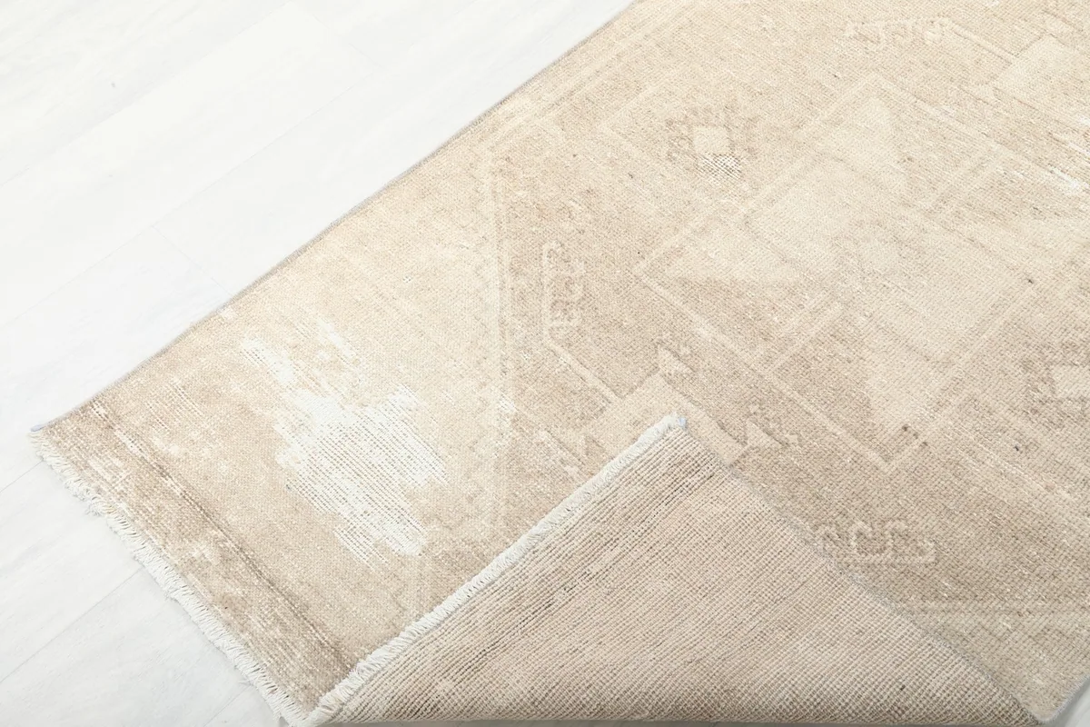 Corner of the runner folded back to reveal the back of the rug and the hand-knotted construction.