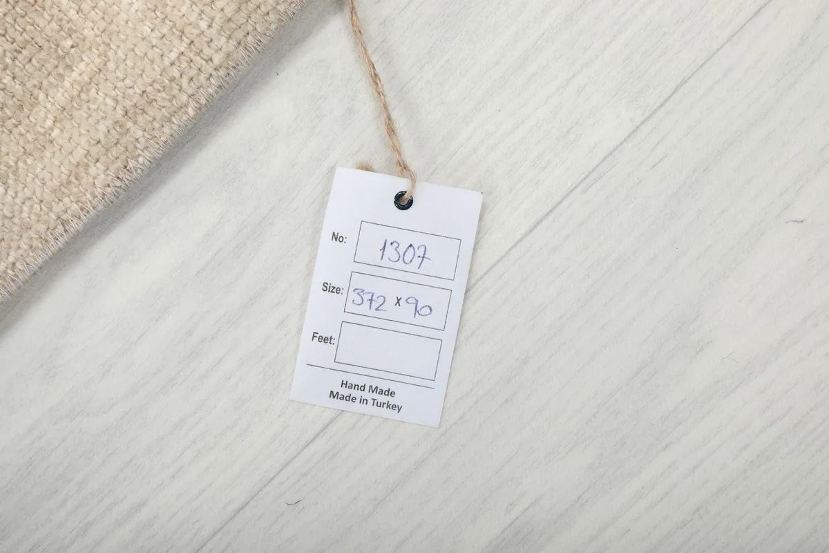 Close-up of the product tag indicating the rug number, size in cm, and origin from Turkey.