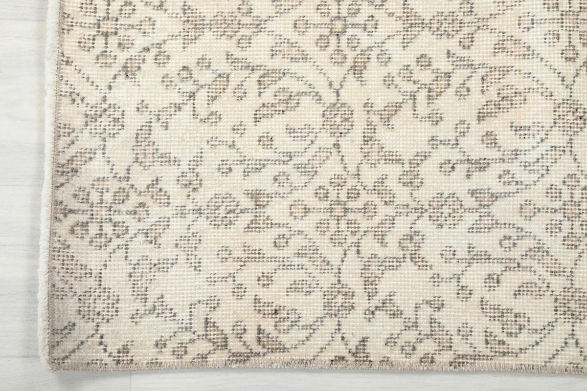 Close-up of the rug's edge, illustrating the subtle border design and the evenness of the hand-knotted work.