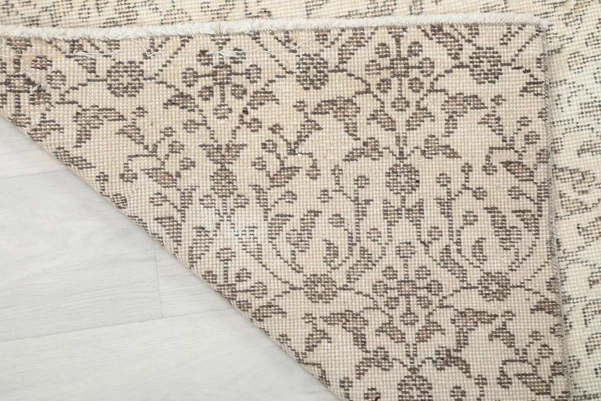 Detailed shot of the rug's reverse side, revealing the tight knotting of the cotton foundation and wool pile.