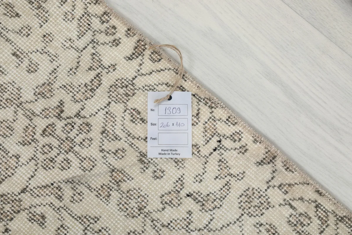 Close-up of the rug's corner with a product tag, confirming it is hand-made in Turkey.