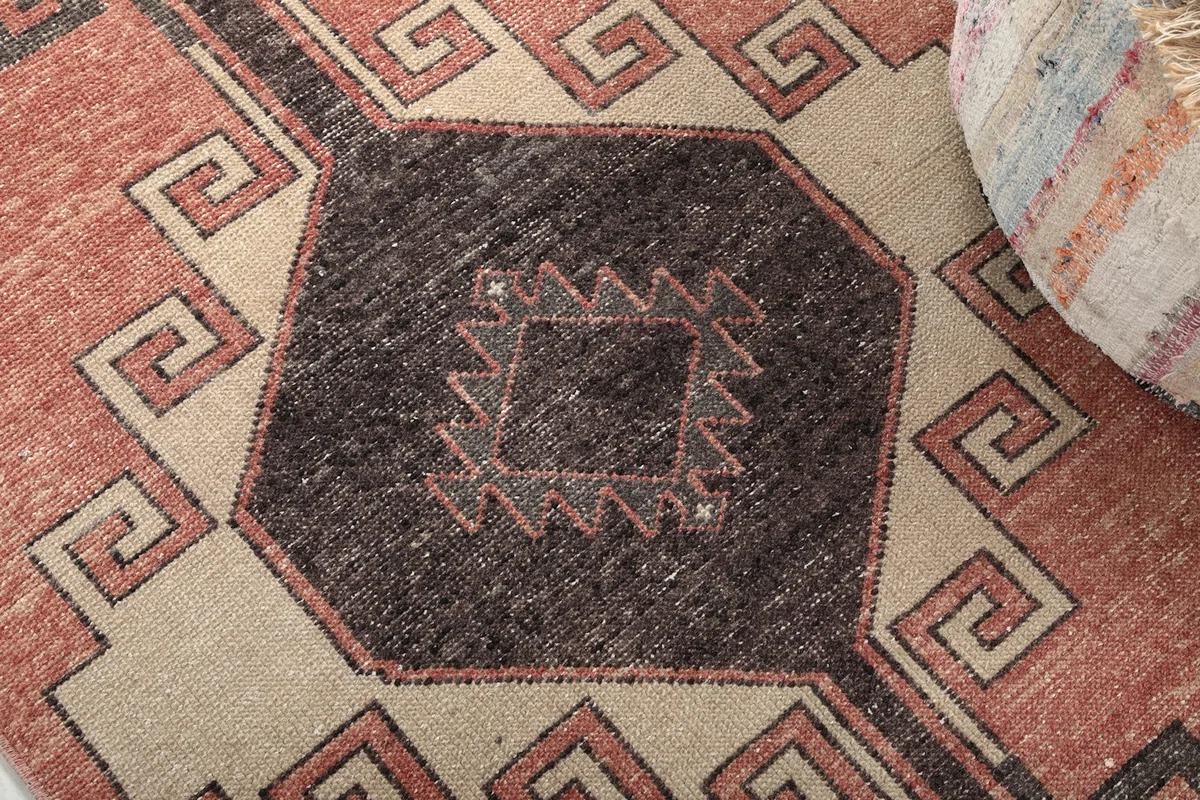 Detailed view of the hand-knotted texture and specific tribal patterns within the charcoal motif