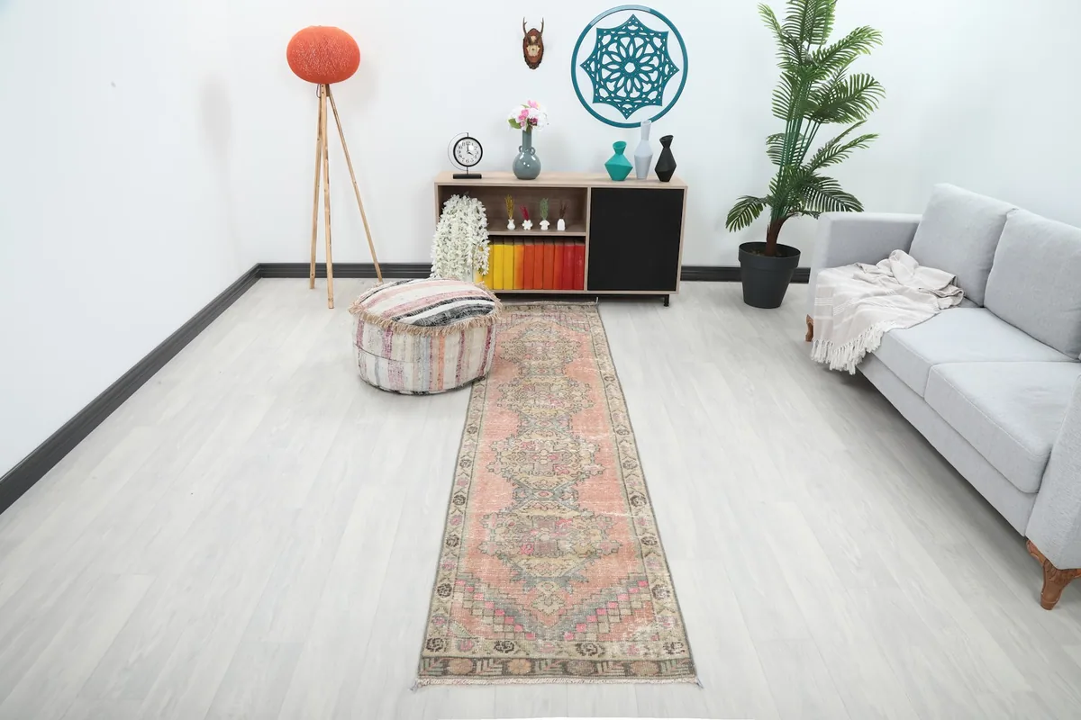 Vintage rose runner rug displayed in a living room setting, showing its long shape