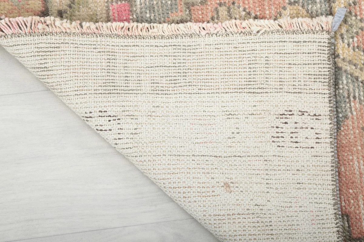 Underside of the rug showing the cotton foundation and the hand-finished fringe