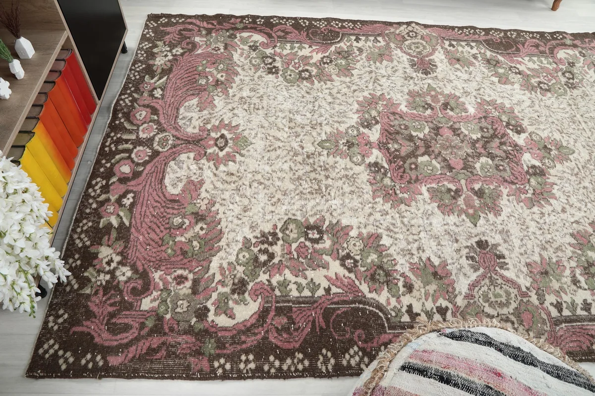Wide angle view of the vintage rug in a living space, showcasing its overall design and size.