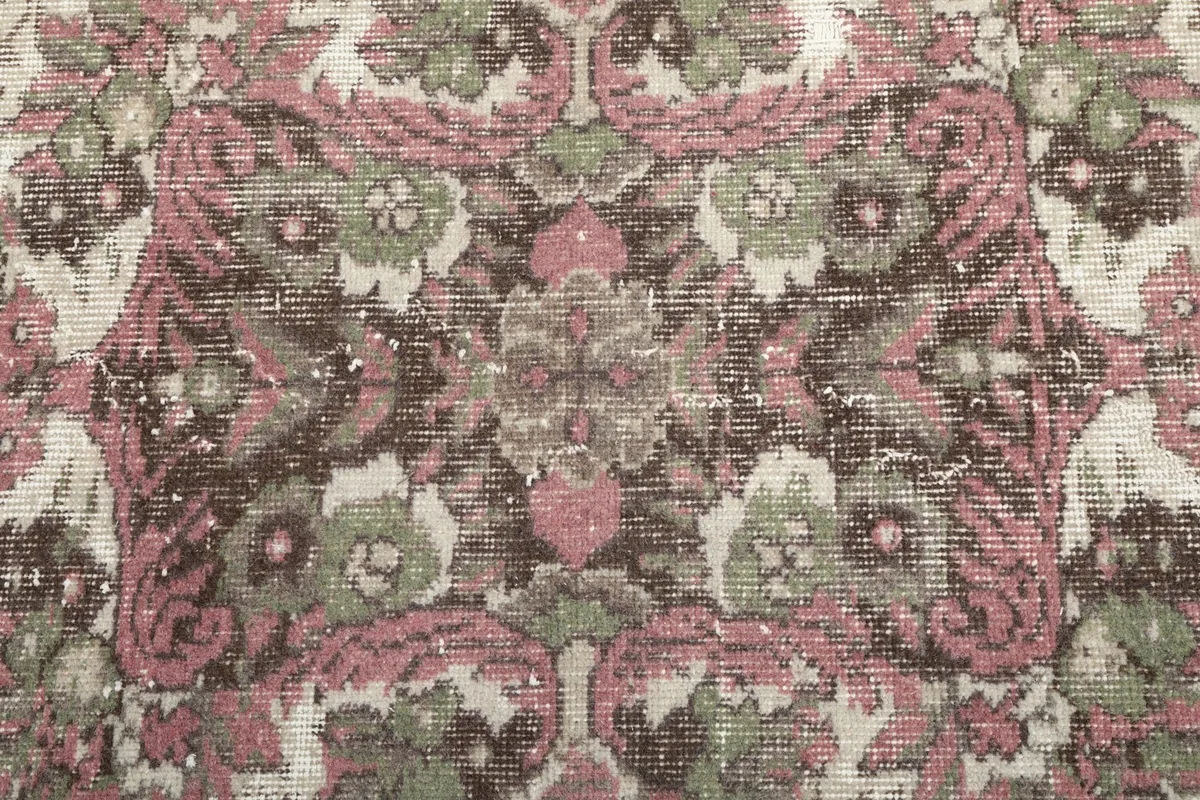 Close-up of the central floral medallion, highlighting the colors and distressed texture.