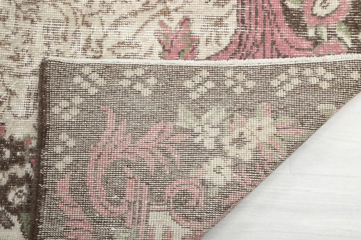 Close-up of the rug's back, showing the hand-knotted construction and foundation material.