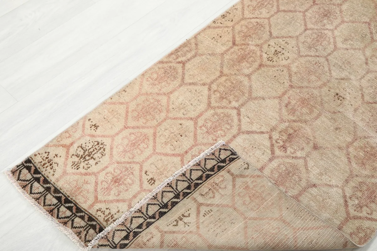 View of the runner rug folded back to show the cotton foundation and reverse side of the pile