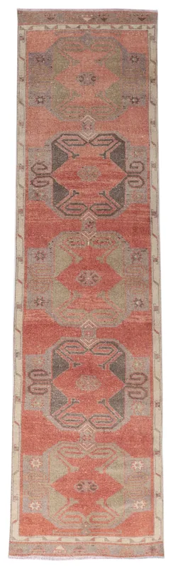 Full overhead view of the rust geometric tribal runner rug on a white background.