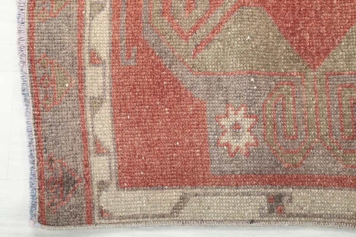 Detail of the border and edge of the rust runner rug, showing its construction.