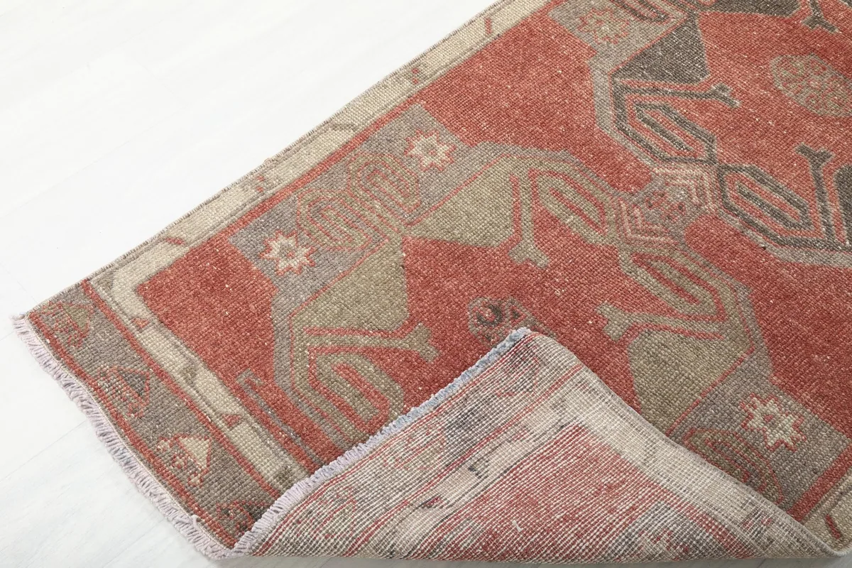 Corner of the rust runner rug folded to show the pile and back of the rug.
