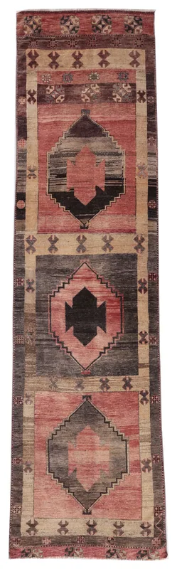 Full overhead view of the rose, gray, and tan geometric tribal runner rug on a white background