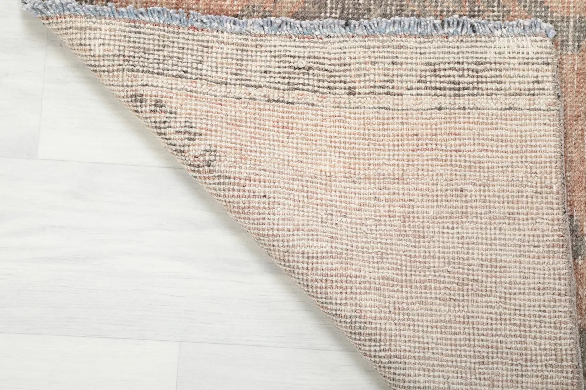 Underside of the runner rug showing the tightly woven cotton foundation and knotting structure.