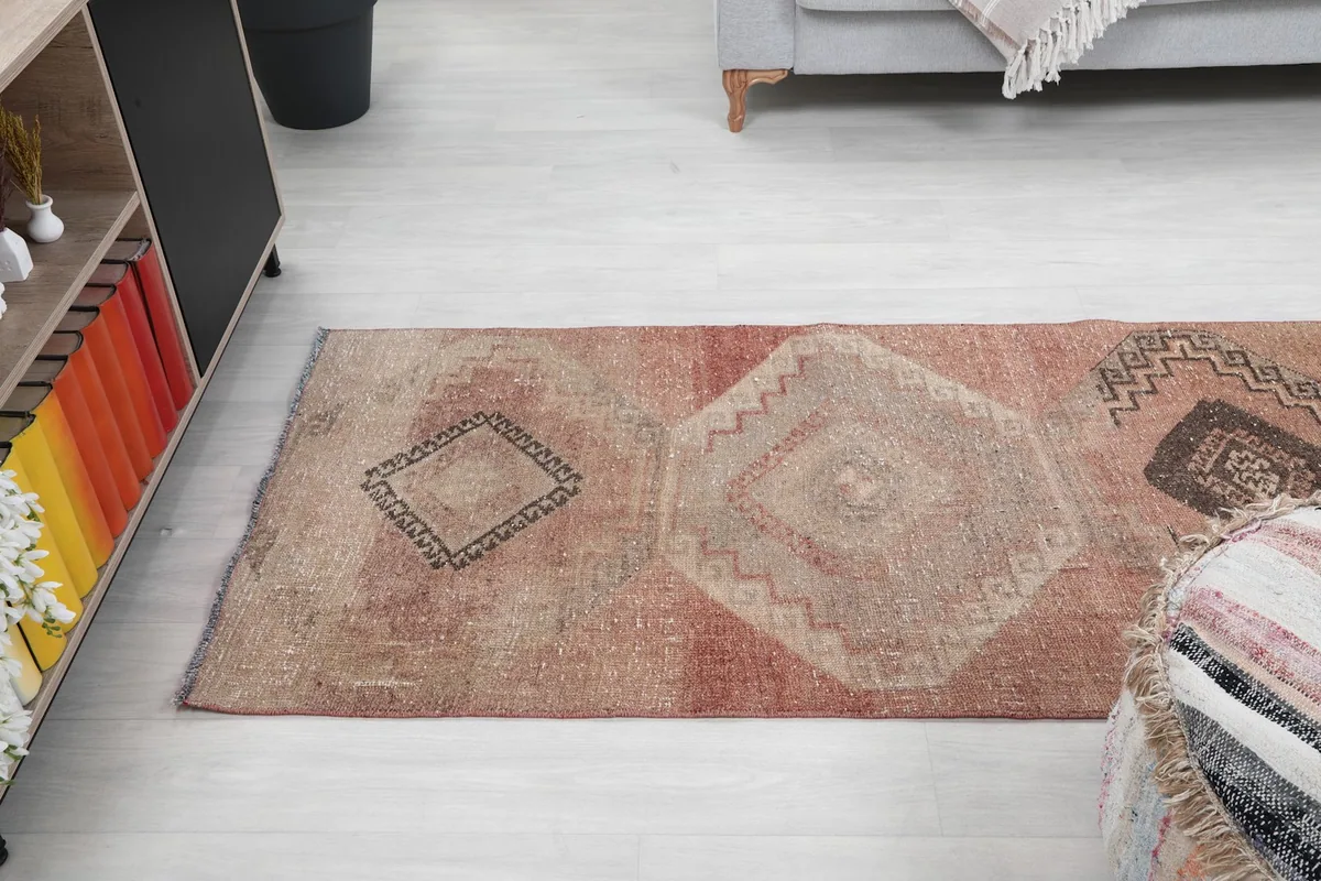 Angled view of the upper half of the runner rug, showing the fading color variations and patterns