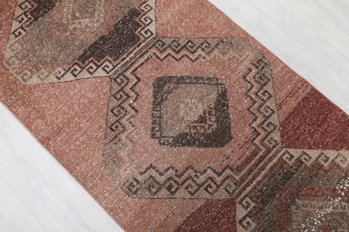 Close-up of a central geometric medallion with brown and charcoal details and a subtle border pattern