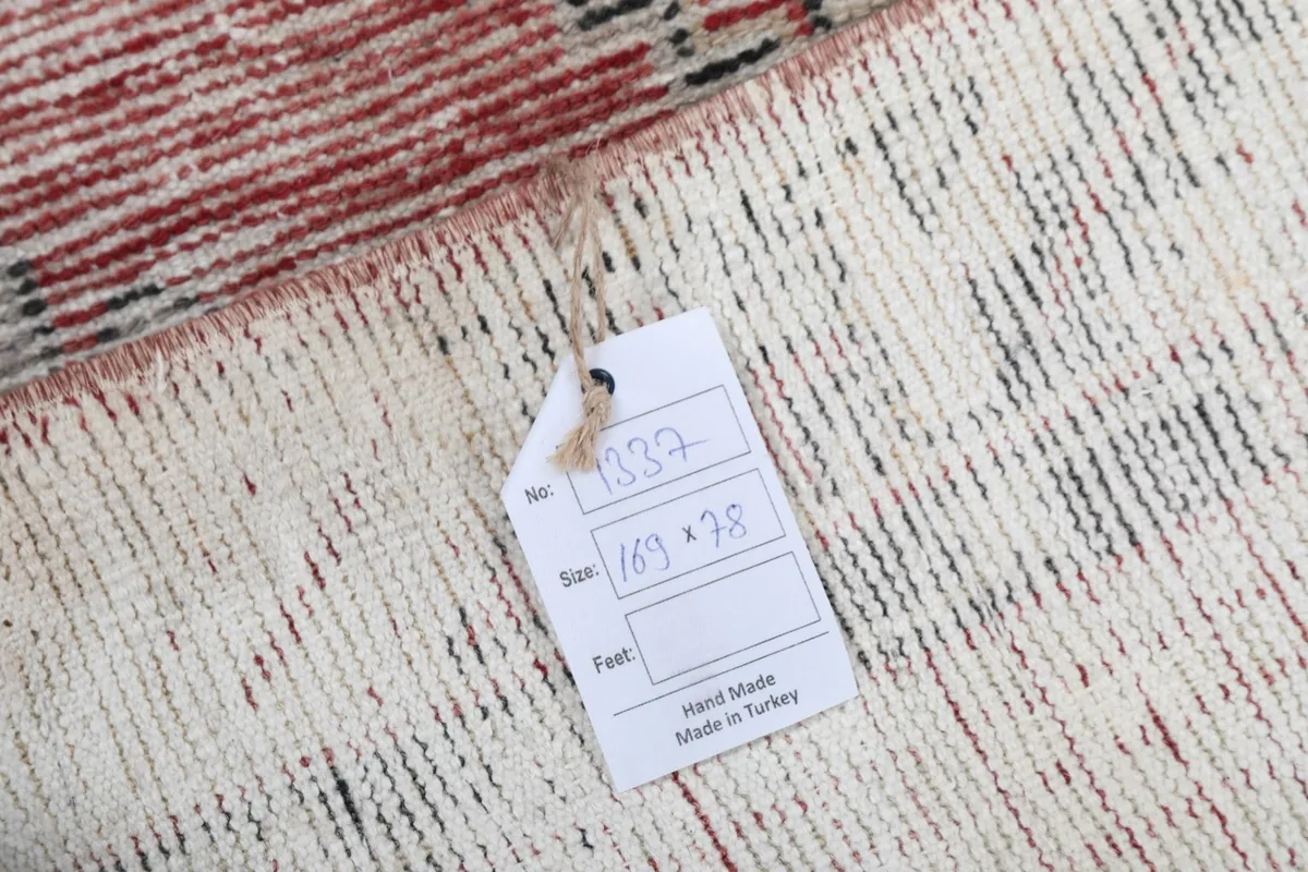 Close-up of the label attached to the rug's back, indicating size and handmade origin
