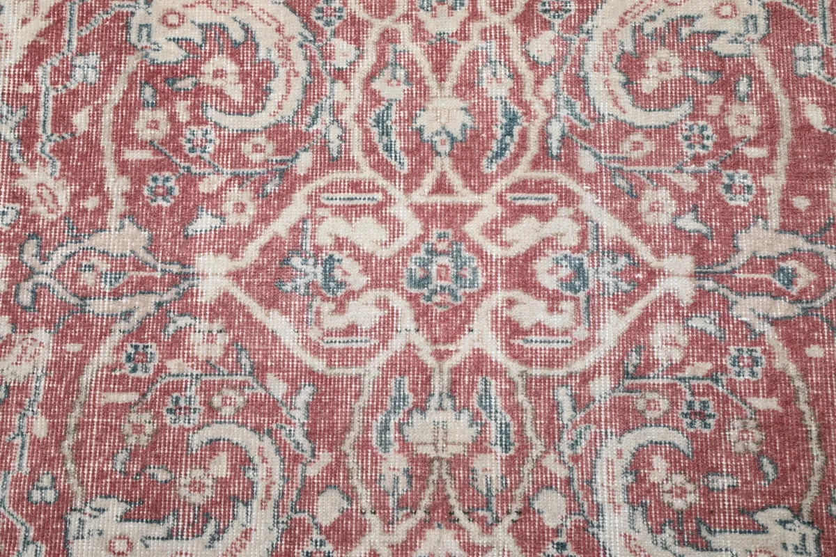 Macro view of the central medallion design on the rust wool pile, highlighting color variations.