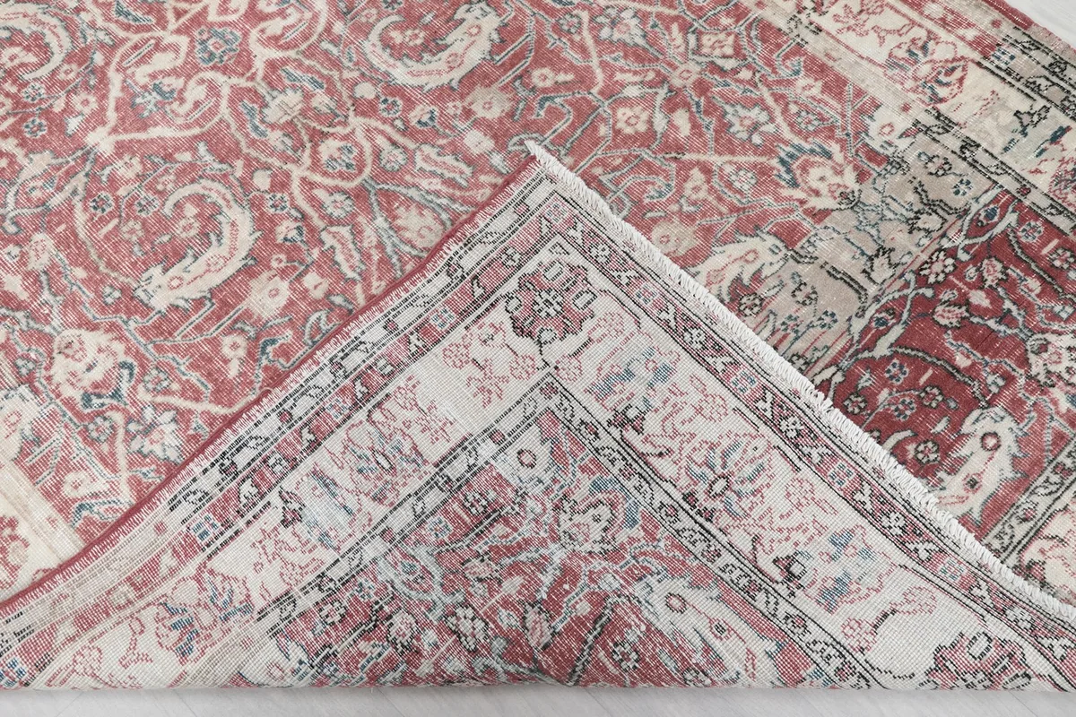 Folded corner of the rug revealing the backside of the hand-knotted wool pile and cotton foundation.